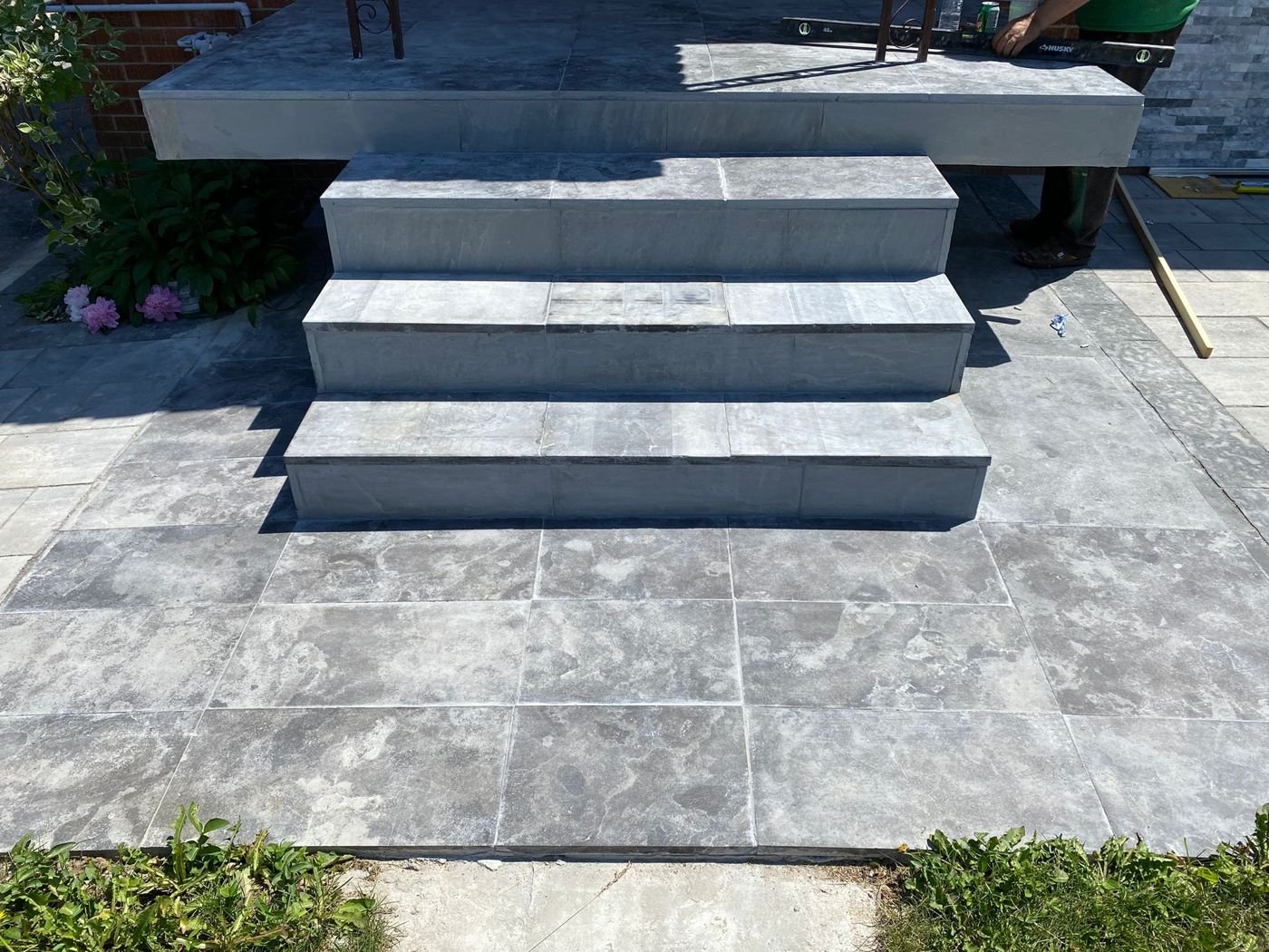Three front steps and a landing with an interlocking paver surround