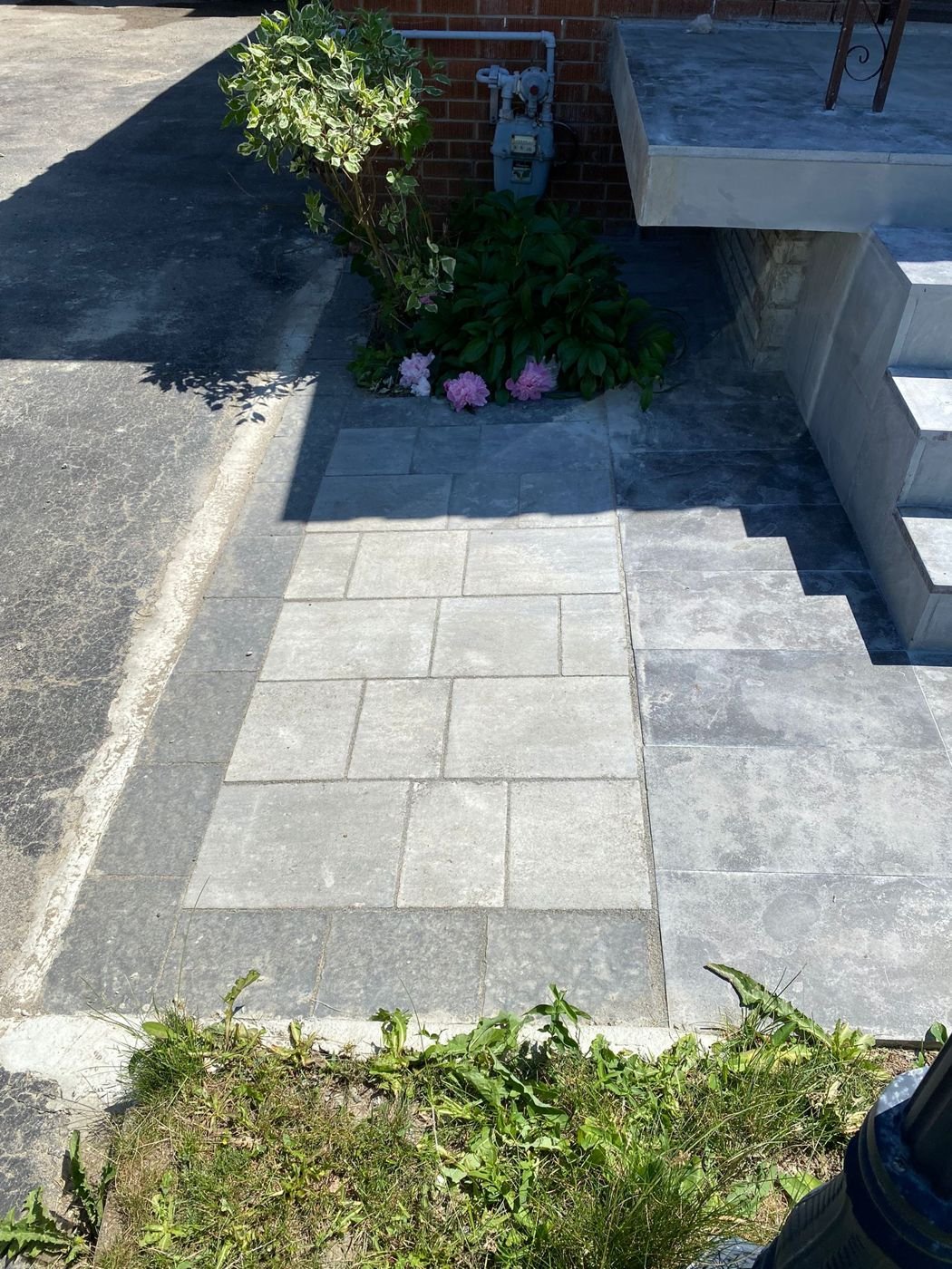 Interlocking paver path leading to new front steps beside a driveway