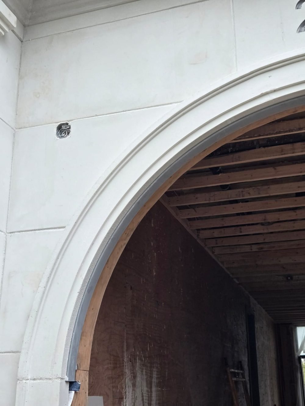 Precast arched opening with a steel lintel running along the inside of the arch