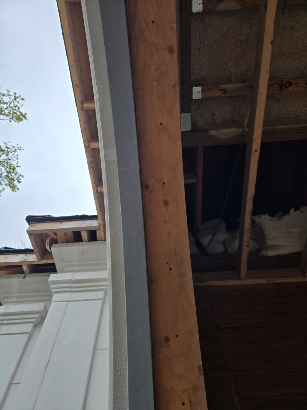 Steel lintel beside a precast pillar and timber framing above an opening